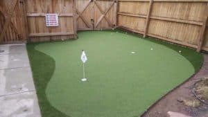 Artificial Turf Putting Green in Backyard with surrounding fence